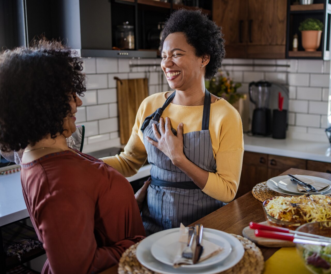 Portrait of two women enjoying lunch at home. They are having fun in the dining room.