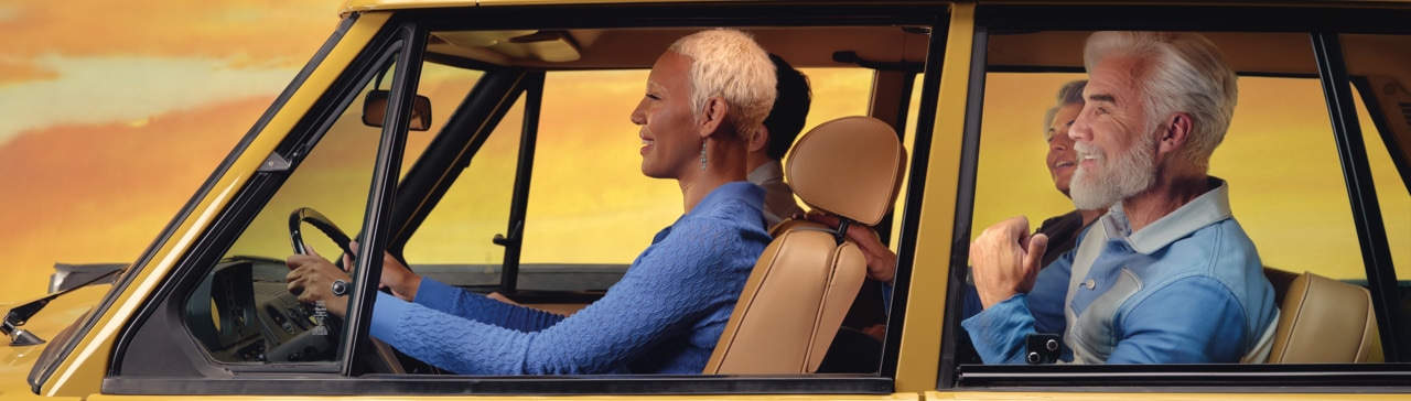 Um carro amarelo com pessoas dentro, visíveis através das janelas