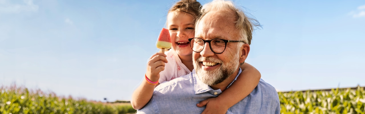 Grandfather carrying granddaughter piggyback