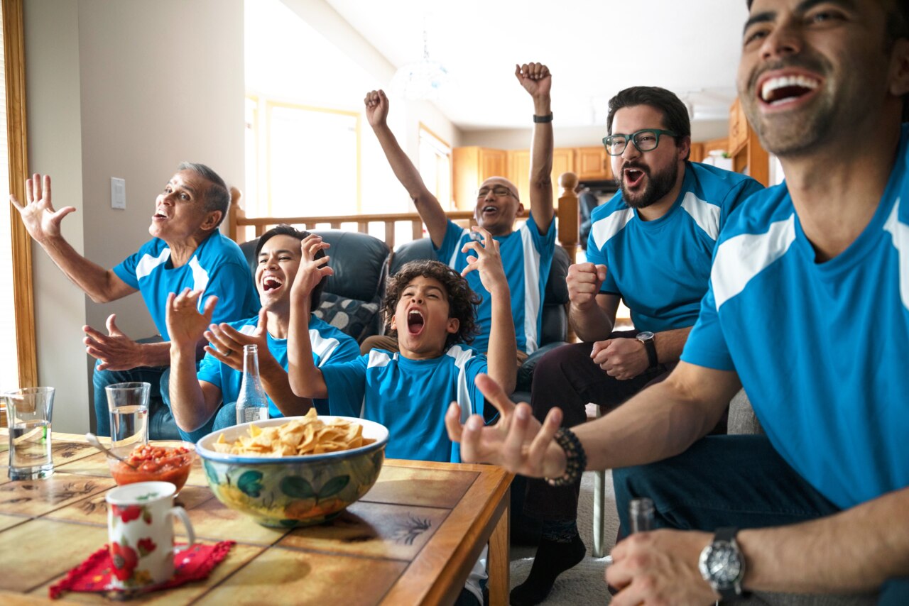 Latinx multi-generation family watching sports and cheering