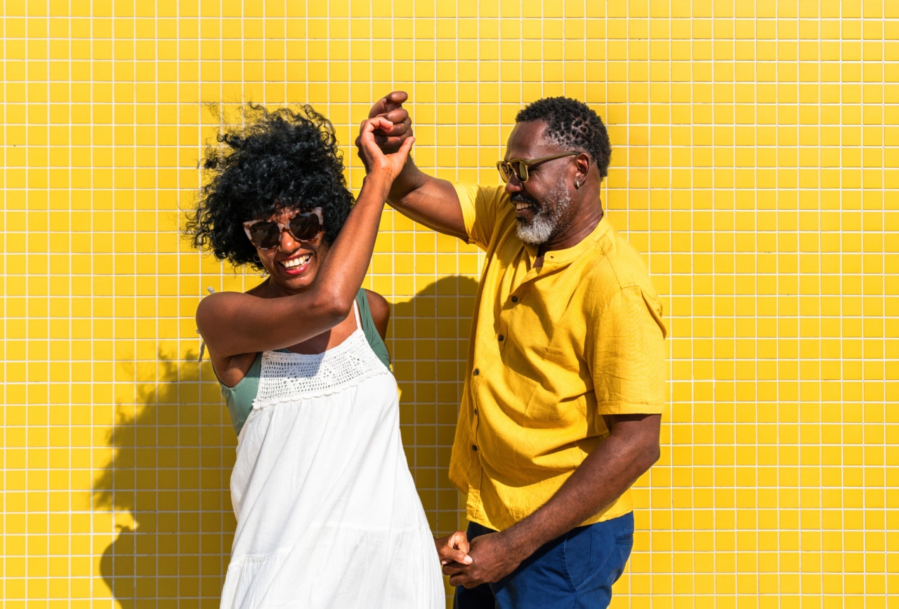 Magnifique couple de personnes noires d’âge mûr en bord de mer — Un couple africain marié, complice et joyeux, profitant d’un moment en plein air. Une scène illustrant la relation, le style de vie et la qualité de vie.