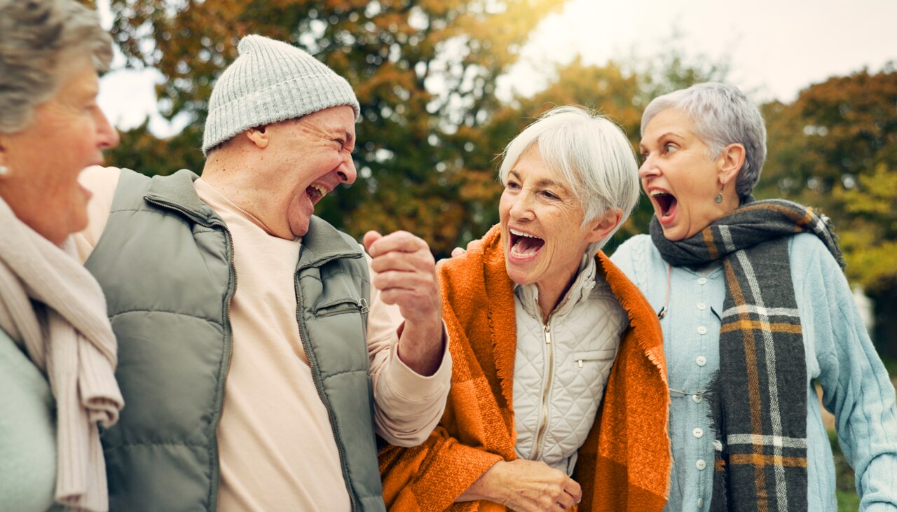 Venner, der griner og ældre mennesker i parken for at knytte bånd, samtale og kvalitetstid sammen udendørs. Pensionering, glad og ældre mand og kvinde i naturen med sjov vittighed, humor og lykke
