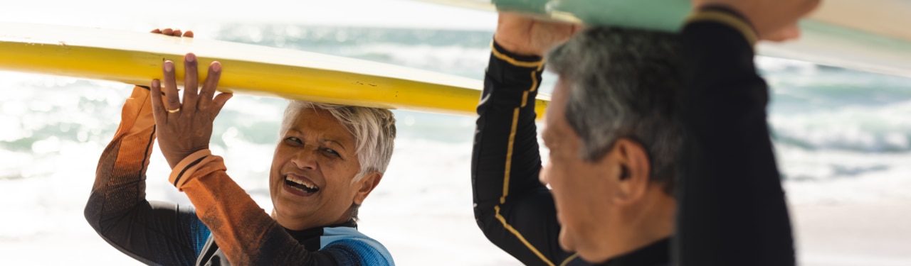 A couple smiles as they surf together 