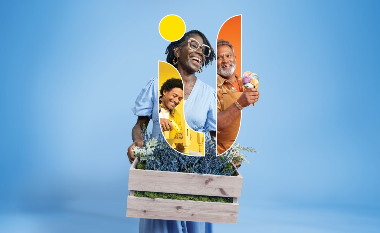 Una persona che tiene in mano una cassa di legno con varie forme e immagini colorate ritagliate, creando un collage di persone e natura su uno sfondo azzurro.