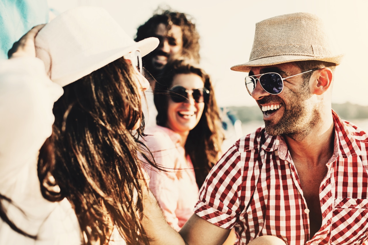 Couple and friends happilly smiling at sumlight.